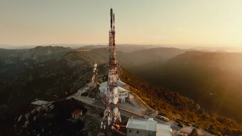 Epic 4K Aerial Drone Orbit of Mountain Communication Towers at Sunrise Above Stock Footage 335119077