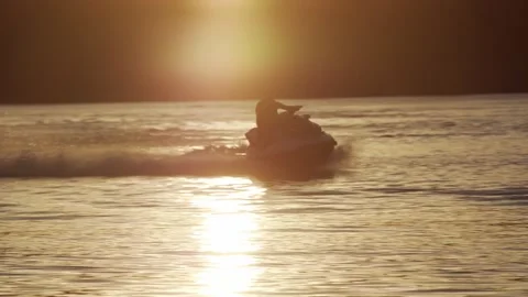 Epic action shot of a man riding a jet ski and spraying water, golden Stock Footage 144822049