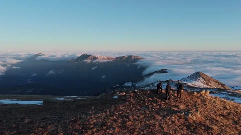 Epic Adventure: Hikers Conquer Mountain Summit Surrounded by Clouds Stock Footage 328340647
