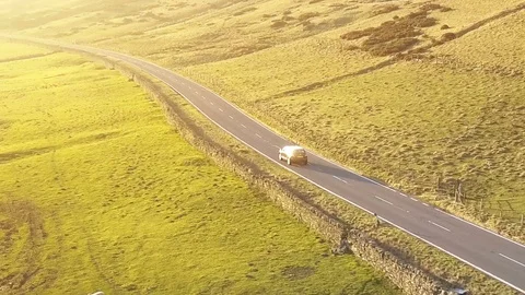 Epic aerial car tracking shot along peaceful road towards sunset CU Stock Footage 105307928