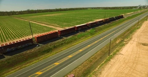 Epic aerial drone shot of train railroad traveling thru rural agriculture area Stock Footage 73609626