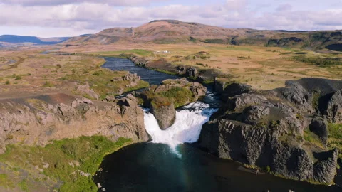 Epic aerial drone view flying over landscape of Hjalparfoss waterfall and lagoon Vidéo 121058271