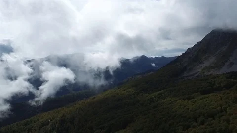 Epic aerial flight over the forest high in the mountains through the clouds Stock Footage 126065376