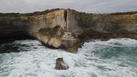 Epic aerial shot of ocean waves rolling towards spectacular limestone cliffs, Gr Stock Footage 335982630