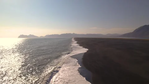 Epic Aerial Sunset Over Black Sand Beach Peninsula Ocean and Mountains Stock Footage 256698482