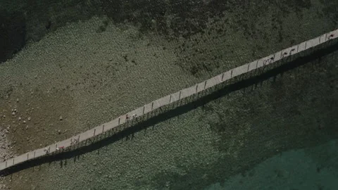 Epic aerial view drone shot of long thin bridge from shore to ocean island. Stock Footage 202080663