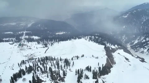 Epic backward aerial pullback revealing the vast snowy valley of Gulmarg. Stock Footage 333801809
