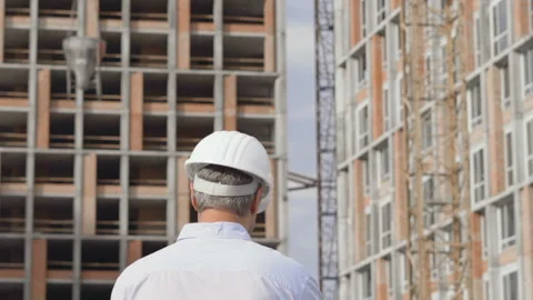 The epic builder works against the gray cloudy sky and clings bricks to the Stock Footage 111996374