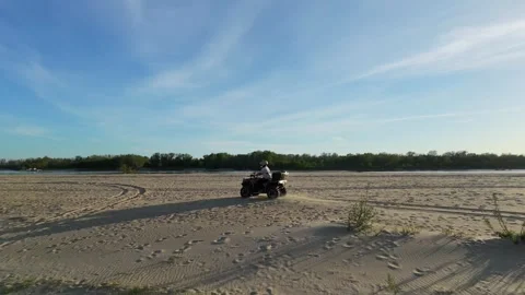 Epic cinematic drone shot of quad bike driving next to a river Stock Footage 334186107