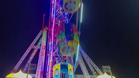 An epic cinematic view of a large luminous giant wheel or Ferris wheel rota.. Stock Footage 313382165