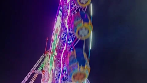 An epic cinematic view of a large luminous giant wheel or Ferris wheel rota.. Stock Footage 313382168