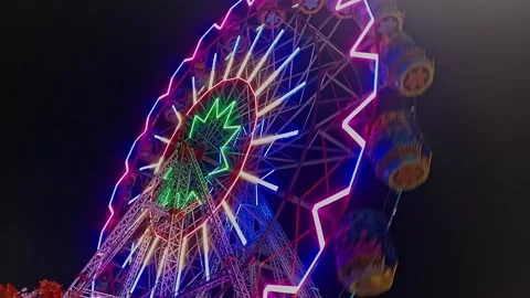 An epic cinematic view of a large luminous giant wheel or Ferris wheel rota.. Stock Footage 313382169
