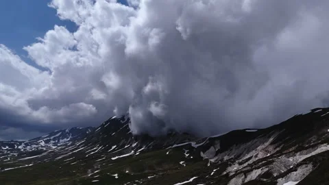 Epic Cumulus Clouds Moving Fast Over Snowy Mountain Range Video stock 337414837