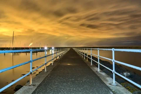 Epic dark yellow sunset clouds over harbor Stock Photos