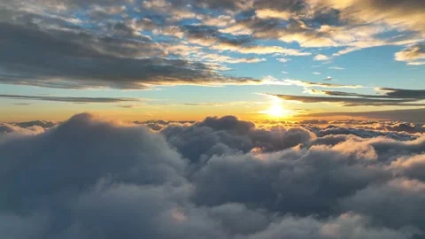 Epic drone flight over clouds during sunrise. White fluffy clouds illuminated by Stock Footage 169147851