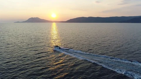 Epic drone flight over a speed boat which drives in the sunset Stock Footage 104265499