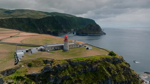 Epic Drone Orbit of Farol de Albarnaz Lighthouse on a Dramatic Rocky Headland Stockbeeldmateriaal 335214231