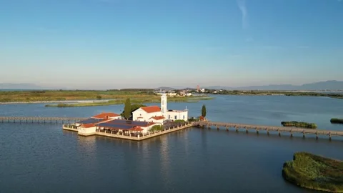 Epic Drone Pullback and Rise Revealing Porto Lagos Monasteries and Lagoon at Stock Footage 340557277