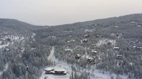Epic drone rotation shot of winter with cabins, trees, and mountains in backg Video stock 145560528