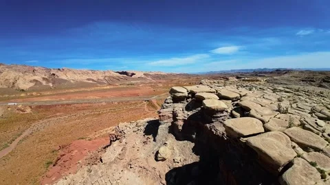 Epic drone shot flying over a rugged cliff edge and a vast red desert valley Vídeos de archivo 331920098