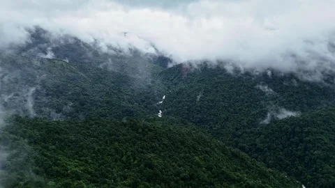An epic drone view of a cascading waterfall lush mountains and forests topp.. 스톡 동영상 314207798