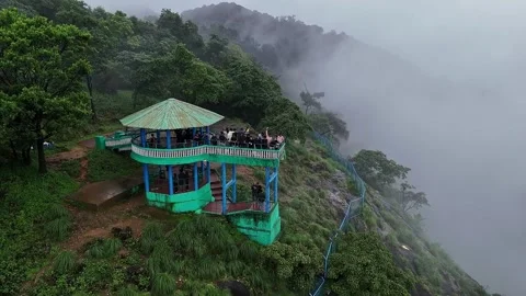 Epic drone view of tourists on a watchtower amid lush forest and swirling m.. Stock Footage 314206725