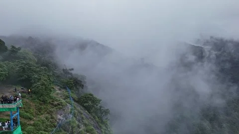 Epic drone view of tourists on a watchtower amid lush forest and swirling m.. Stock Footage 314206844