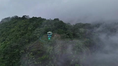 Epic drone view of a watchtower amidst jungle on a mountains edge, covered .. Stock Footage 314206779