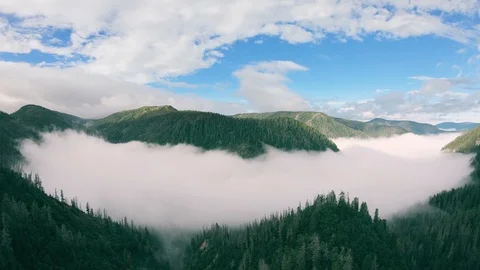 Epic flight over beautiful valley surrounded with mountains and covered with fog Stock Footage 121897071