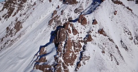 Epic fly on the drone rock covered with snow. Steep rocks among the snow. Video stock 100705823