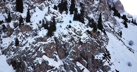 Epic fly on the drone rock covered with snow. Steep rocks among the snow. Video stock 100705835