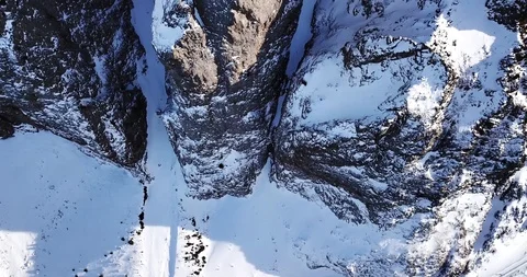 Epic fly on the drone rock covered with snow. Steep rocks among the snow. Stock Footage 100707520