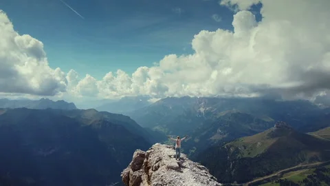 Epic fly over woman with raised hands on the top of Piz Boe mountain Stock Footage