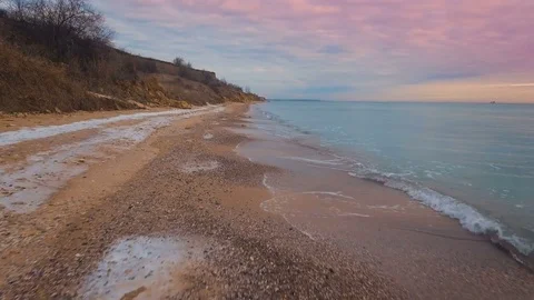 Epic flying drone to over the winter beach during a beautiful pink sunset. 4K. Vídeo Stock 71093339