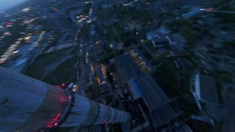 Epic FPV Dive Past Chimney with City Lights Powering On at Dusk Video stock 310303523