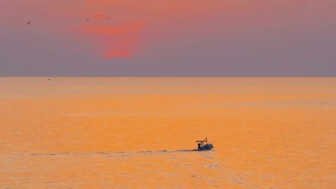Epic golden sunset sky with a motor boat cruising in the open ocean with a sun Stock Footage 151692201