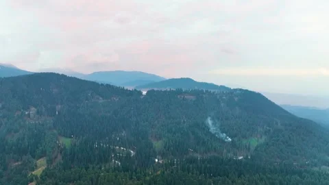 Epic high-altitude pullback revealing the vast pine-covered Gulmarg valley. Видео 333802164