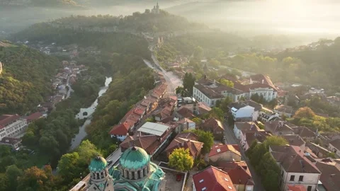Epic morning sunlight pierces dense fog over historic Veliko Tarnovo, Bulgaria 動画素材 341689010