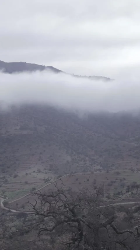 Epic Mountain Peak Rising Above Thick Clouds in Ait Issafen Stock Footage 332776514