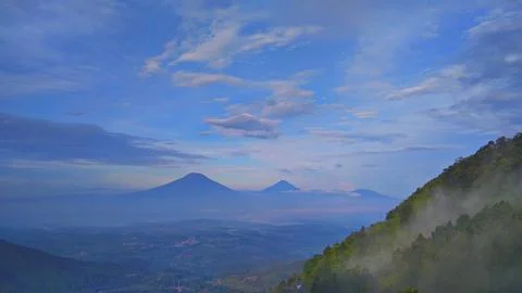 Epic Mountain Range View Over Misty Valley and Village Stock Photos