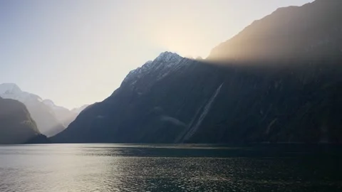 Epic orange warm sunlight shining through mountain peak in New Zealand Stock Footage 289417077
