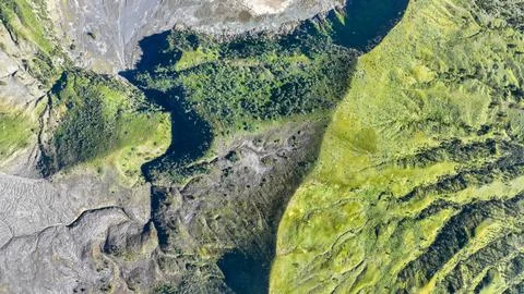 Epic overview of Bromo shadowed volcanic rim embracing verdant hills and valleys Foto stock
