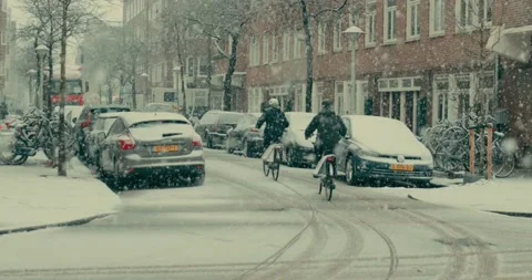 An epic shot of cyclists riding bikes during heavy snowfall in Amsterdam 4k Stock Footage 236121931