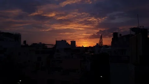 An epic shot of sunset view over urban skyline beneath orange and blue sky Stock Footage 325763912