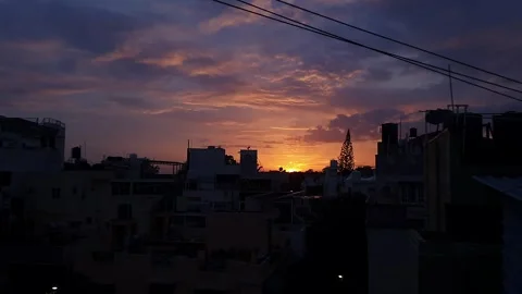 An epic shot of sunset view over urban skyline beneath orange and blue sky 스톡 동영상 325764339