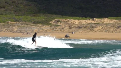 Epic slowmo of quad on the beach with surfer crossing by Stock Footage 94558143