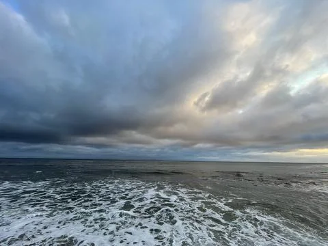 Epic Storm Clouds Over the Pacific Ocean During Sunset Crashing Waves Stock Photos
