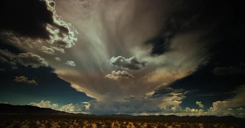 Epic summertime storm clouds roil the sky over the Arizona desert. Stock Photos