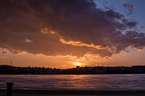 An epic sunset with a crimson sunset. a dramatic sky with clouds over a froze Stock Photos