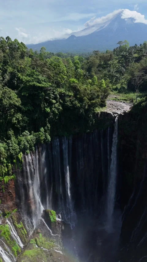 Epic Vertical Aerial of Waterfall and Active Volcano Mount Semeru, Indonesia 4K Stock Footage 329629850